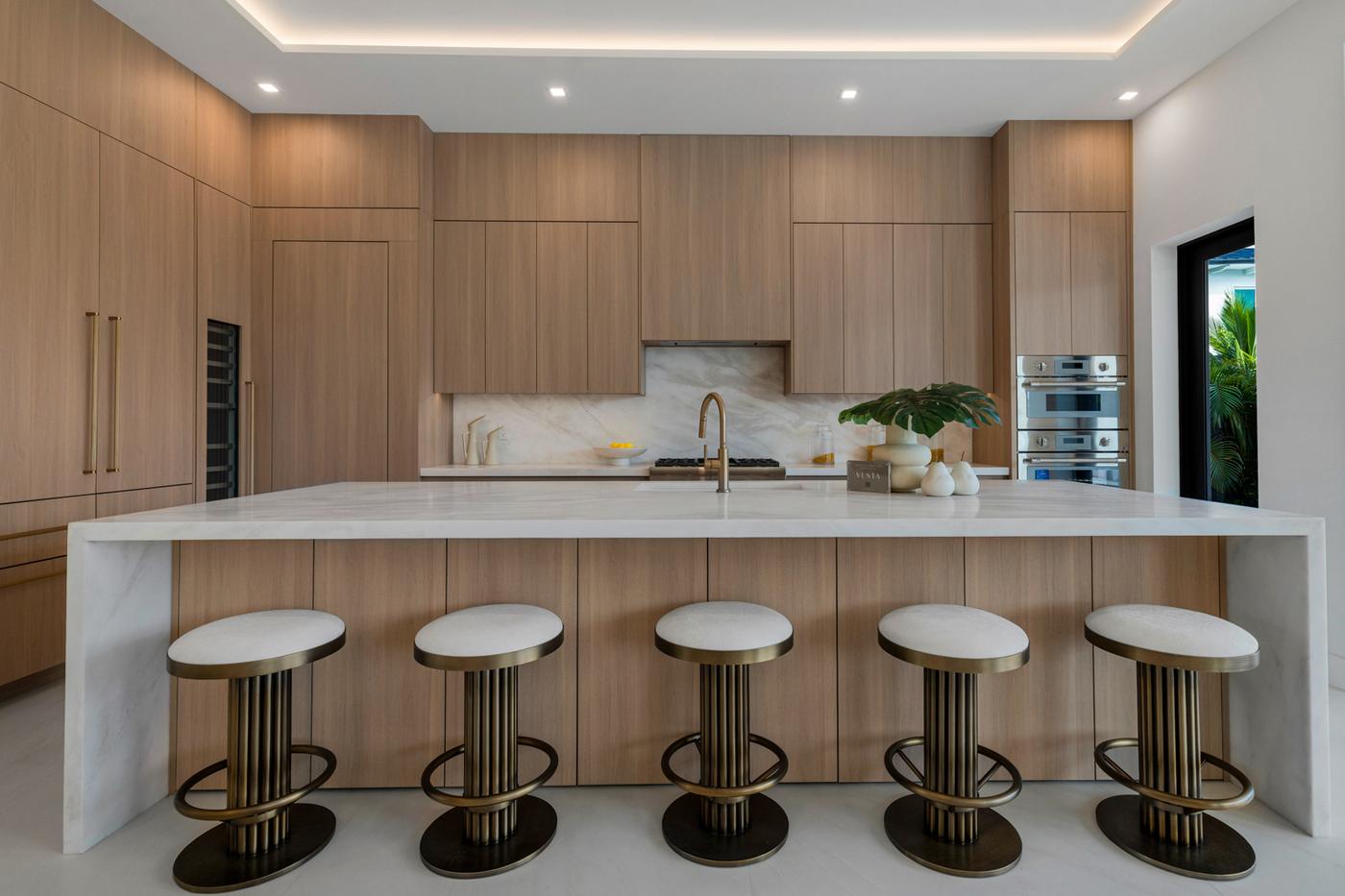 Kitchen at 252 SW 14th Place with waterfall stone island and oak cabinetry